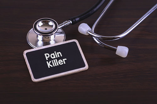 Stethoscope and name tag saying pain killer