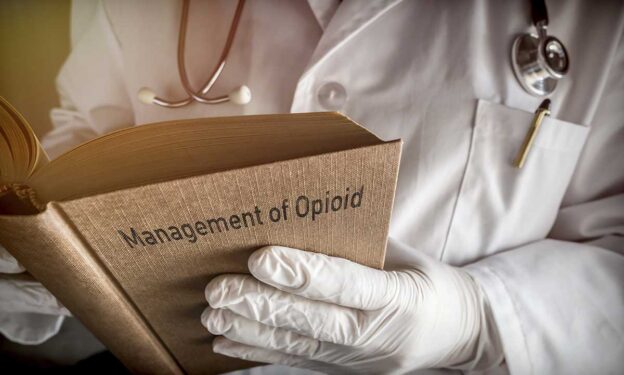 Close up photo of a doctor holding a book on opioid management - concept of most common Percocet questions answered